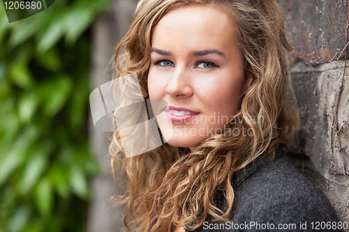Image of Young female leaning against wall