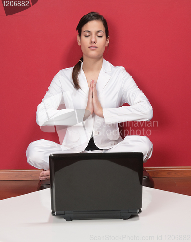 Image of Businesswoman meditating in yoga lotus position