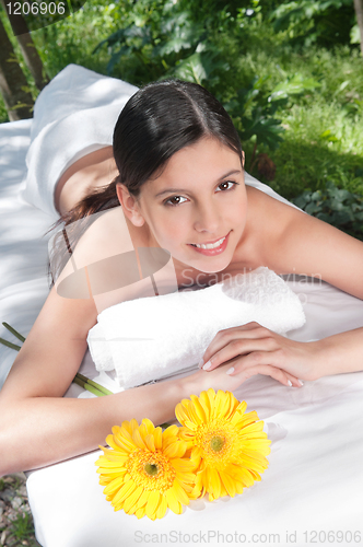 Image of Beautiful young woman with flowers around