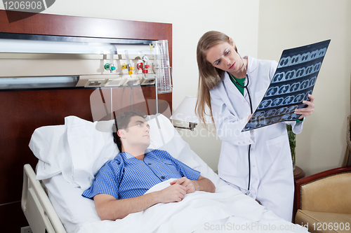 Image of Doctor showing report to the patient
