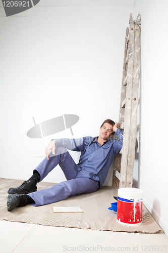 Image of Thoughtful mature man sitting on floor