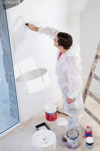 Image of Workman painting the wall with a roller