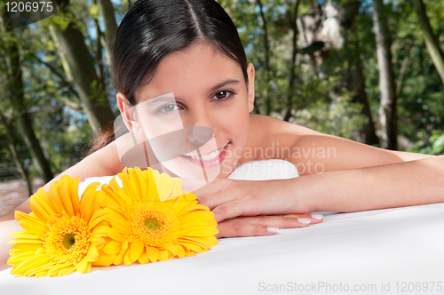 Image of Beautiful young woman with flowers around