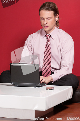 Image of Concentrated businessman using a laptop
