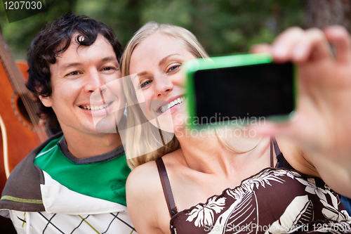Image of Young cheerful couple photographing themselves