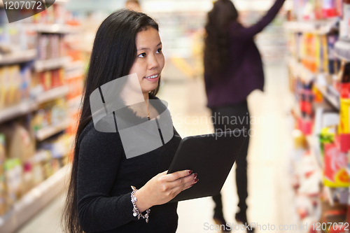 Image of Woman using digital tablet in shopping centre