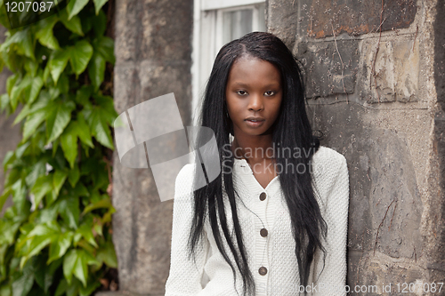 Image of African American standing in front of stone wall