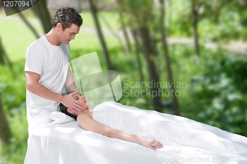 Image of Beautiful young woman getting a face massage