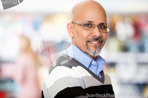 Image of Mature man smiling while shopping