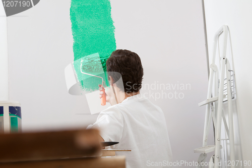 Image of Man painting the wall with a roller