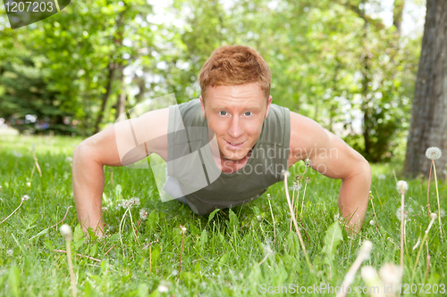 Image of Portrait of man doing a push up