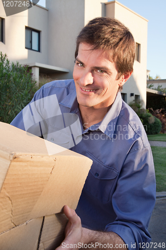 Image of Portrait of smiling man holding box