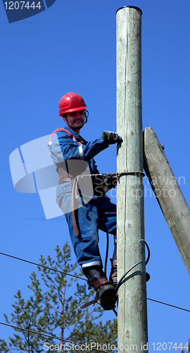 Image of Electrician on a pole makes installation work