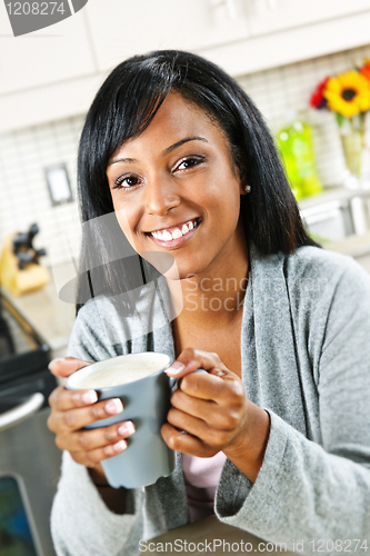 Image of Woman in kitchen with coffee cup