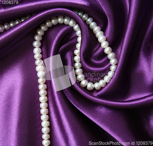 Image of White pearls on a lilac silk background 