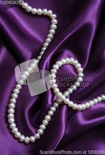 Image of White pearls on a lilac silk background 