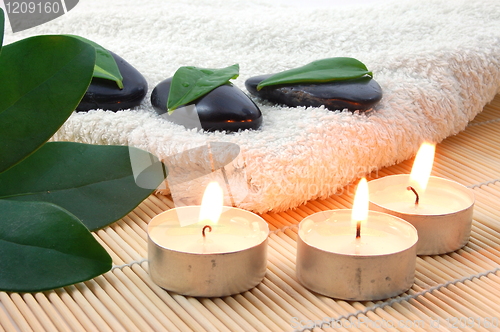 Image of foldet white bath towel and zen stones