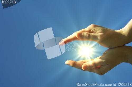 Image of hand sun and blue sky