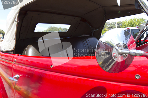 Image of Close up detail of a red classic car .