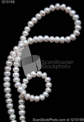 Image of White pearls on the black silk as background