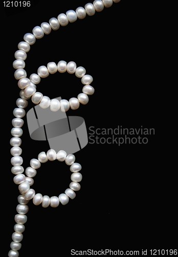 Image of White pearls on the black silk as background