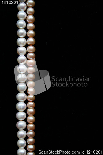 Image of White and pink pearls on the black background