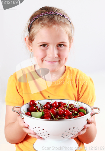 Image of Child holding a bowl of fresh cherries
