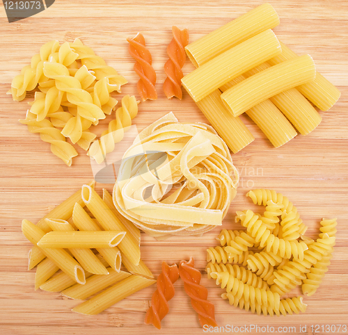 Image of Different kinds of pasta on the wooden background 