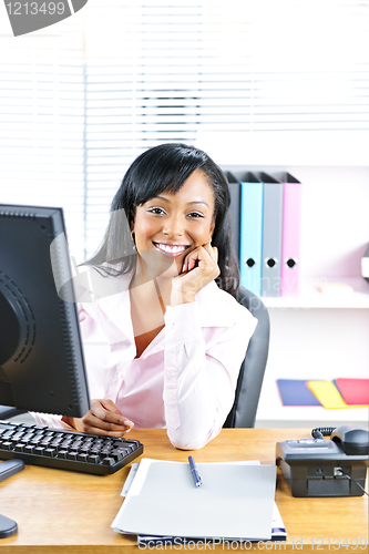 Image of Smiling black businesswoman at desk