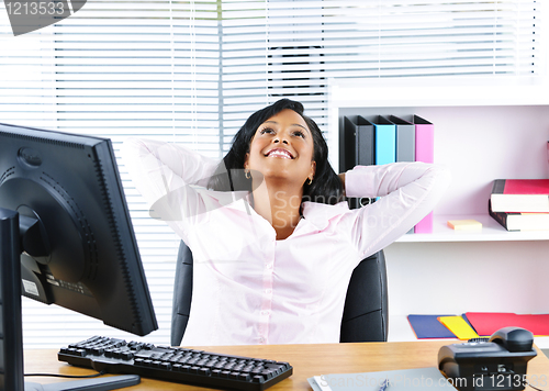 Image of Black businesswoman resting at desk