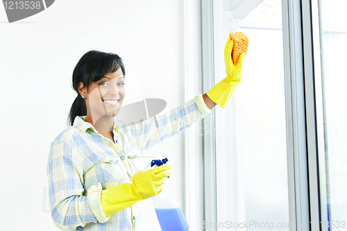 Image of Smiling woman cleaning windows