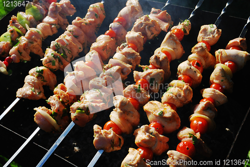 Image of grilled meat on metal skewers