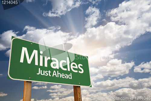 Image of Miracles Green Road Sign Against Clouds