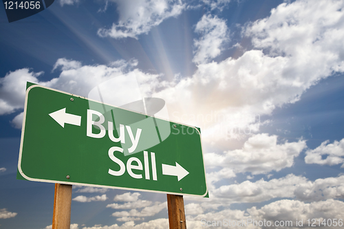 Image of Buy, Sell Green Road Sign Against Clouds