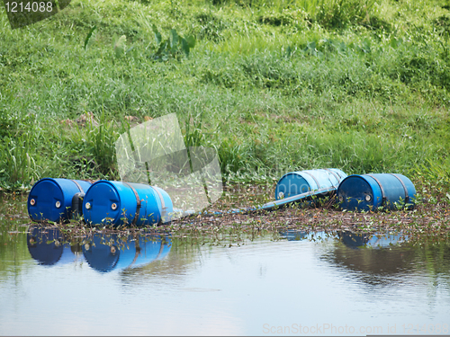 Image of Blue toxic drums in river