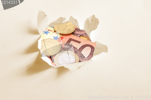 Image of euro money behind hole in paper