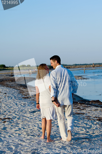 Image of Young couple walking on beach