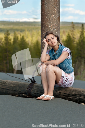 Image of sad girl sitting on a log