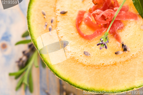 Image of fresh melon soup with parma ham and lavender flower