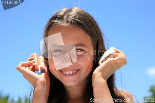Image of beautiful girl with shell at the beach in Summer vacation