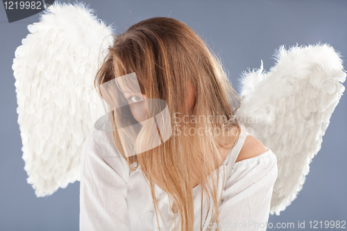 Image of beautiful blonde angel against grey  background