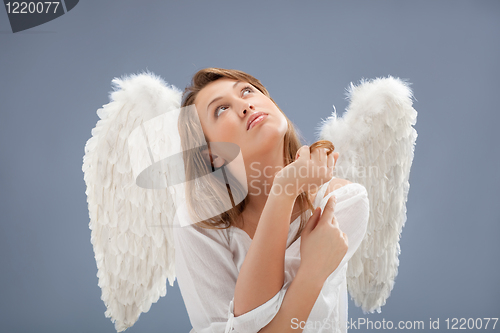 Image of beautiful blonde angel against grey  background