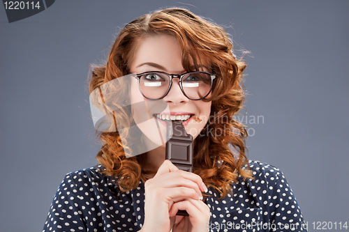 Image of happy smiling woman eating chocolate