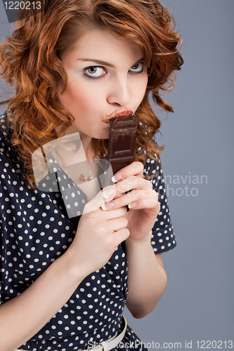 Image of happy smiling woman eating chocolate