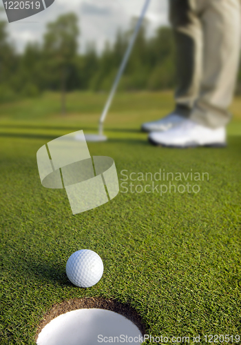 Image of Golfer putting, selective focus on golf ball 