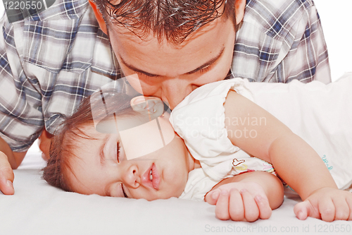 Image of Father kissing his baby sleeping