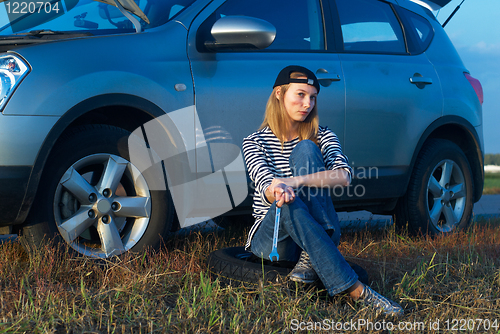 Image of Young Blond Woman With Her Broken Car