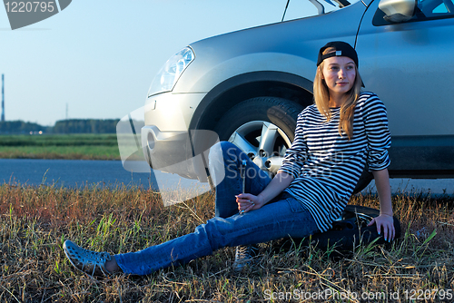 Image of Young Blond Woman With Her Broken Car