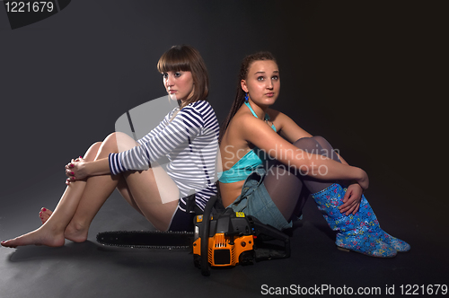 Image of Two pretty girls with chainsaw