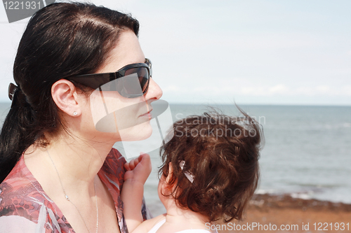 Image of Mother and daughter enjoy hot summer weather at the beach.